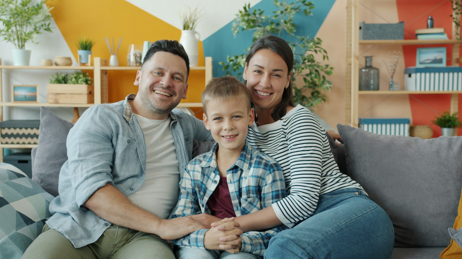 A family of three together on a sofa at home