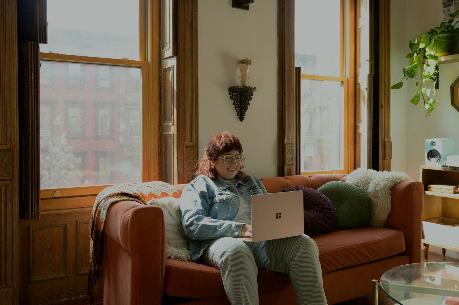 A woman on a sofa comparing plans on her laptop