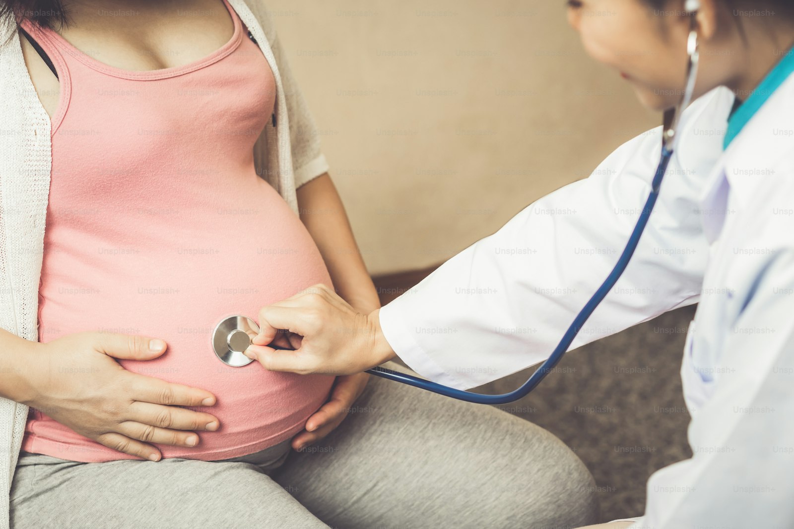 A doctor listening with a stethoscope during a prenatal check