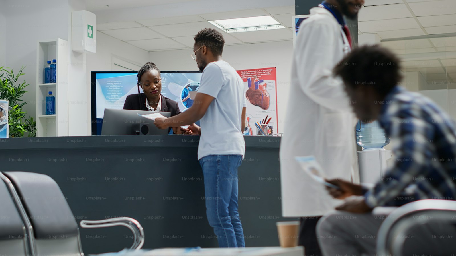 A patient handing admission paperwork to a receptionist