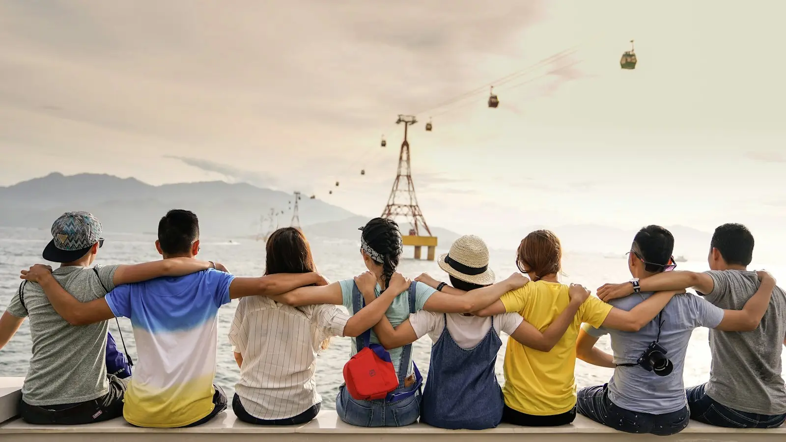 Friends sitting arm in arm looking out over a city