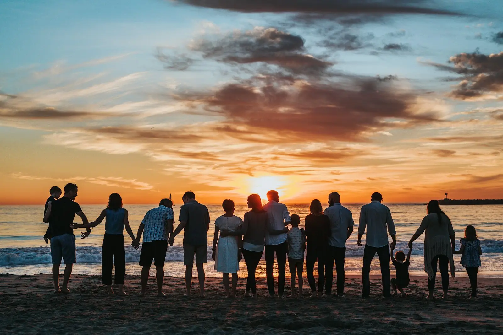 A large group of family and friends watching the sunset on a beach