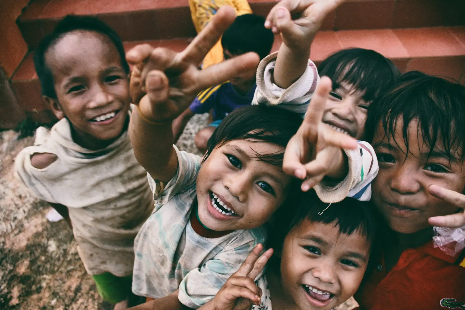A group of children smiling and waving at the camera